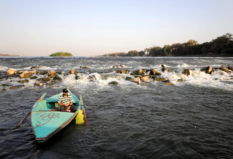 A man fishes in the Nile near Al Qanater as Egypt faces a heatwave.
