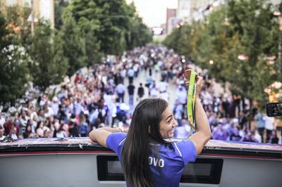 Kosovo's judoka Majlinda Kelmendi shows her gold medal to the supporters during a welcoming ceremony in Pristina on August 14, 2016. - Majlinda Kelmendi made history in Rio de Janiero by becoming the first athlete from Kosovo to win an Olympic gold medal. (Photo by ARMEND NIMANI / AFP)