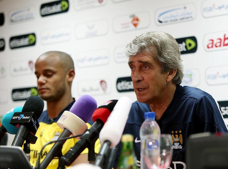 Manchester City captain Vincent Kompany, left, and manager Manuel Pellegrini, right, during a press conference before Wednesday's training session. Satish Kumar / The National / May 14, 2014