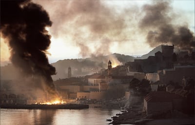 Smoke and flames rise from the harbour inside the walled city of Dubrovnik on November 12, 1991, after it was bombarded by the Yugoslavian Federal Army. Peter Northall / AFP