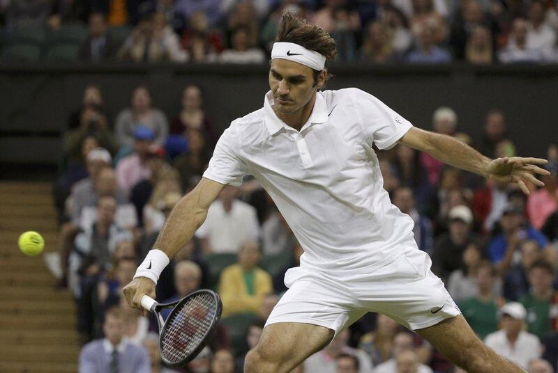 Roger Federer hits a return against Gilles Muller in his second-round win at the 2014 Wimbledon Championships on Thursday. Max Rossi / Reuters / June 26, 2014