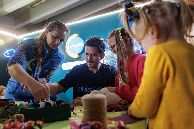 Bloom makes a candle with Milana, 8, and her sister Alisa, 3, during a class at the Unicef Spilno Child Spot at a metro station. Reuters