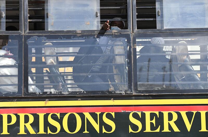 Liban Abdullahi Omar, who was acquitted of aiding the gunmen involved in the Westgate Mall attack of September 2013, waves from inside the Kenya prisons service bus.  AFP