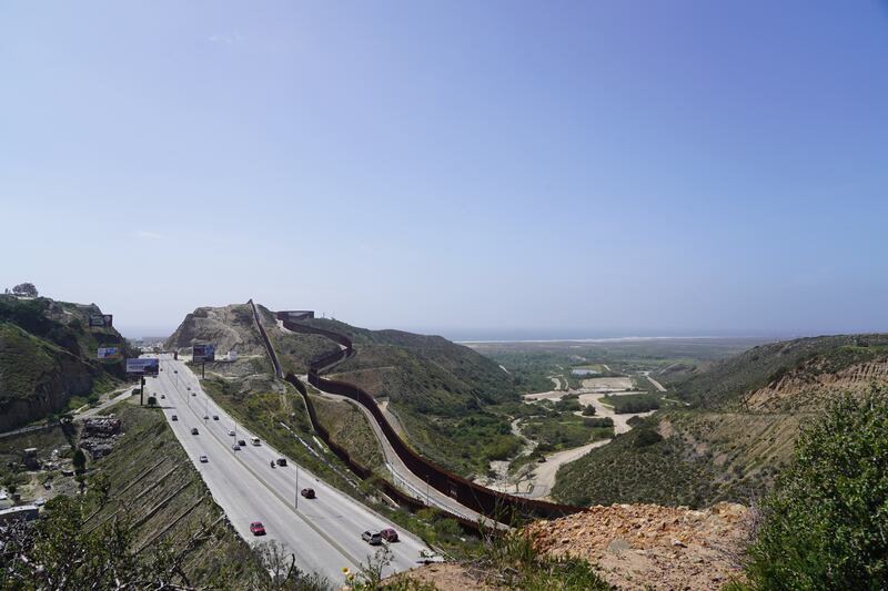 The US border fence stretches towards the Pacific Ocean.