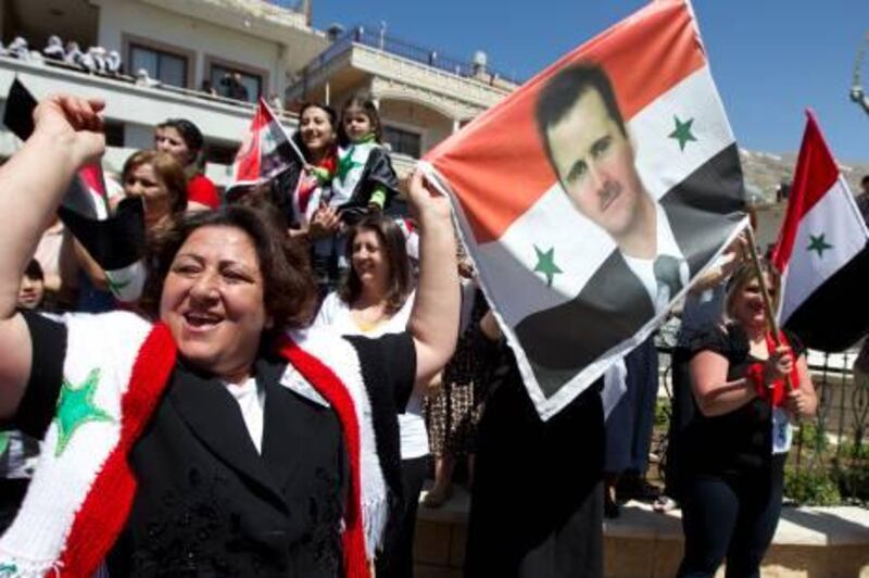 Druze residents of the the Israeli-occupied Golan Heights hold up a portrait of Syrian President Bashar al-Assad and flags during a rally in the Druze village of Majdal Shams on April 17, 2012, to mark Syrian Independance Day. AFP PHOTO/JACK GUEZ