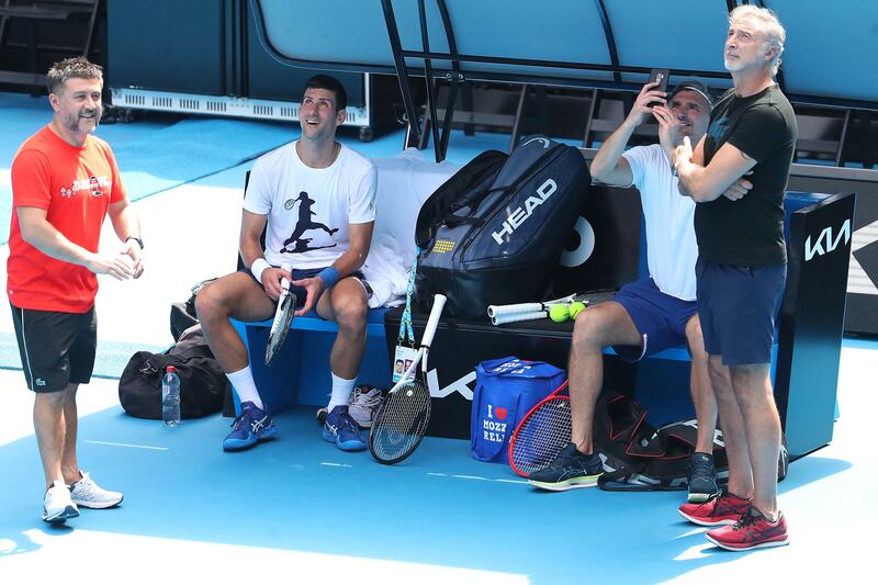 Serbia's Novak Djokovic watches as coach Goran Ivanisevic films news helicopters flying above as they take part in a training session in Melbourne. AFP