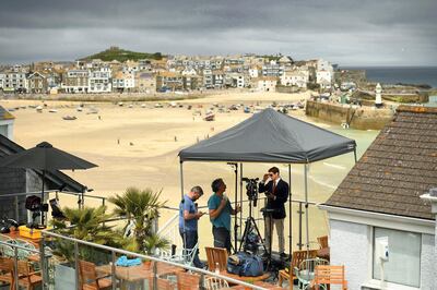 A television crew prepare to broadcast from Carbis Bay, Cornwall on June 10, 2021, ahead of the three-day G7 summit being held from 11-13 June.  G7 leaders from Canada, France, Germany, Italy, Japan, the UK and the United States meet this weekend for the first time in nearly two years, for the three-day talks in Carbis Bay, Cornwall. - 
 / AFP / Oli SCARFF
