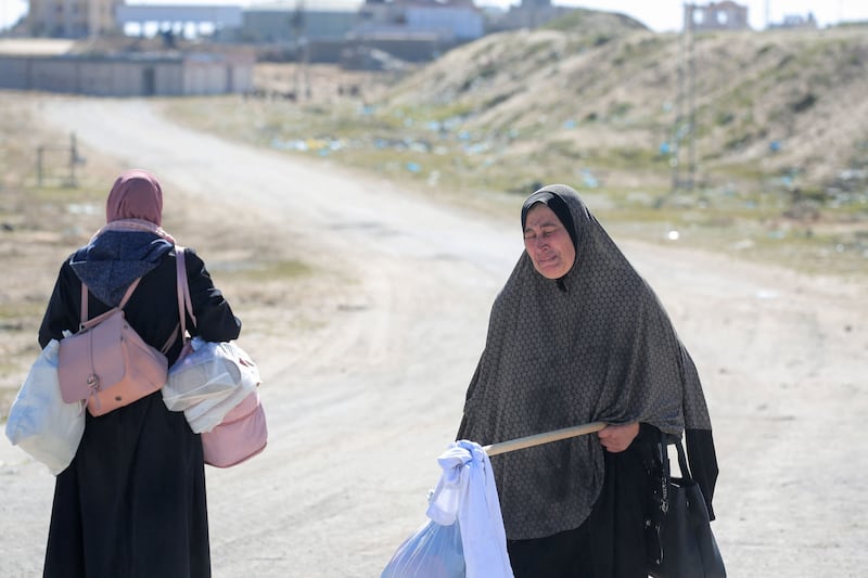 A Palestinian woman carries a white flag while fleeing from the Hamad City area of Khan Yunis. AFP