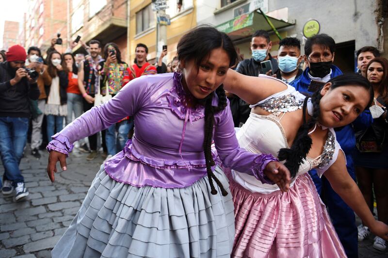 Cholita wrestlers fight it out while Electropreste festival goers look on. Reuters