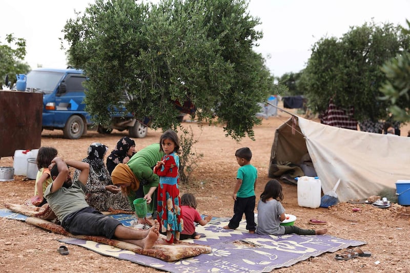 Syrians who fled shelling by regime forces and their allies in the Jihadist-held Idlib province, rest in an olive grove where displaced families took refuge, near the village of Aqrabat, in the Harem district of the same province on the border with Turkey on May 31, 2019.    / AFP / Nazeer Al-khatib
