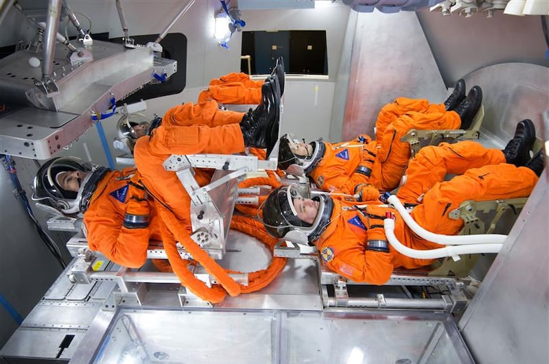 Spacesuit engineers sit in the Orion seats to test the suits the astronauts will wear. Photo: Canadian Space Agency