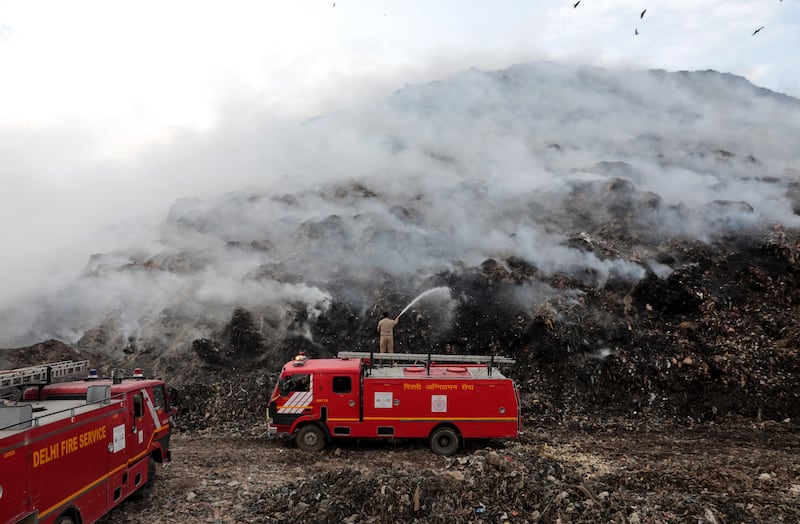 Firefighters try to put out a blaze at a landfill site in Ghazipur, New Delhi. EPA