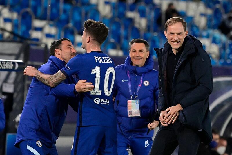 Chelsea's American midfielder Christian Pulisic ("L) celebrates with Chelsea's German coach Thomas Tuchel and teammates after scoring during the UEFA Champions League semi-final first leg football match between Real Madrid and Chelsea at the Alfredo di Stefano stadium in Valdebebas, on the outskirts of Madrid, on April 27, 2021. (Photo by JAVIER SORIANO / AFP)