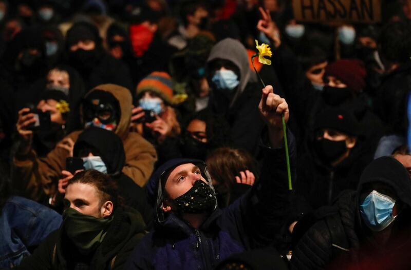 A demonstrator holds a flower during a protest.  Reuters