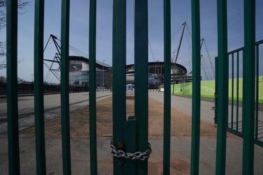 FILE - In this file photo dated Thursday, April 9, 2020, gates stand locked outside the closed English Premier League soccer Manchester City Etihad Stadium, in Manchester, northern England. Guidance for sports bodies was published by the government on Saturday May 30, 2020, as COVID-19 lockdown restrictions are being eased further, allowing Sports events to resume in England from upcoming Monday, without any spectators and providing they comply with the government's coronavirus protocols. (AP Photo/Jon Super, FILE)