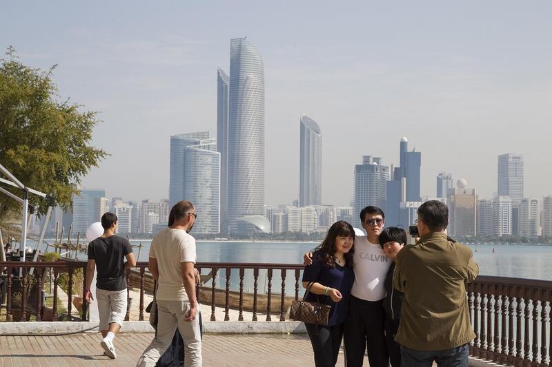 Tourists take photos outside the Heritage village in Abu Dhabi. Mona Al-Marzooqi/ The National 