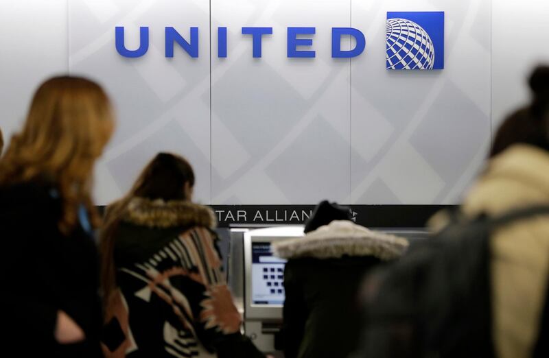 FILE- In this March 15, 2017, photo, people stand in line at a United Airlines counter at LaGuardia Airport in New York. A dog died on a United Airlines plane after a flight attendant ordered its owner to put the animal in the plane's overhead bin. United said Tuesday, March 13, 2018, that it took full responsibility for the incident on the Monday night flight from Houston to New York. (AP Photo/Seth Wenig, File)