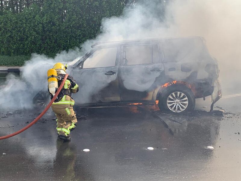 A firefighter extinguishing a car on fire. Road accidents are one of the most common causes of traumatic brain injuries.