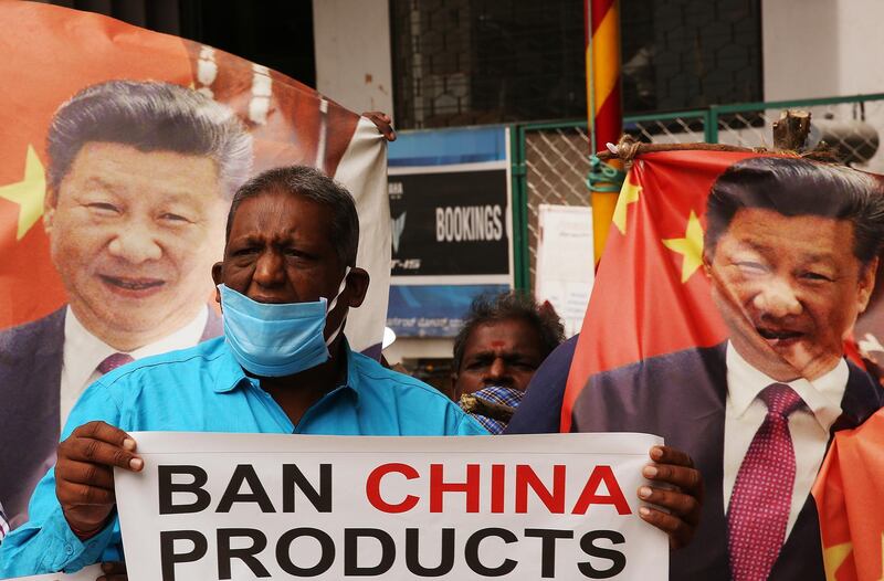 Activists hold photos of Chinese President Xi Jinping and shout slogans against China during a protest in the southern Indian city of Bangalore. EPA