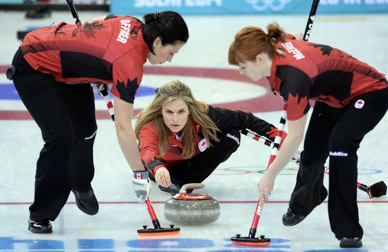 Canada's Jennifer Jones trows the stone as her team mates Jill Officer, left, and Dawn McEwen sweep during women's curling against Russia at the Ice Cube Curling Center on Saturday. Andrej Isakovic / AFP