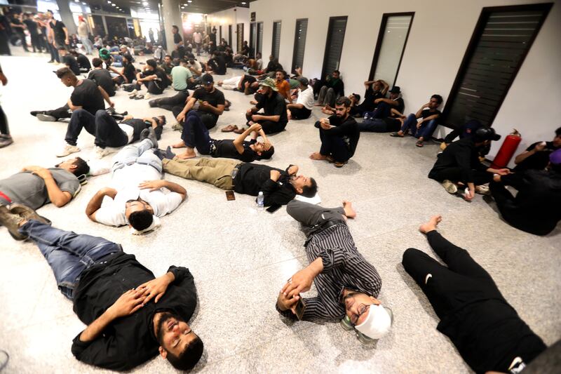 Supporters of Moqtada Al Sadr, head of the Sadrist movement, rest after storming the parliament building in the Green Zone in central Baghdad. EPA