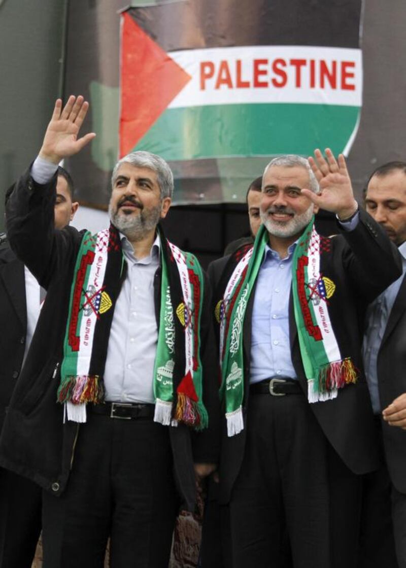 Hamas chief Khaled Mashaal, left, and senior Hamas leader Ismail Haniyeh, right, wave to supporters during a rally to mark the 25th anniversary of the Hamas militant group in Gaza city. Hatem Moussa / AP