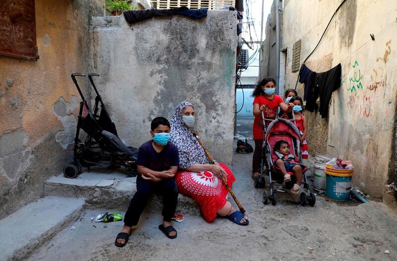 Mask-clad residents of the Askar Palestinian refugee camp, east of the occupied West Bank city of Nablus, gather in an alley. AFP