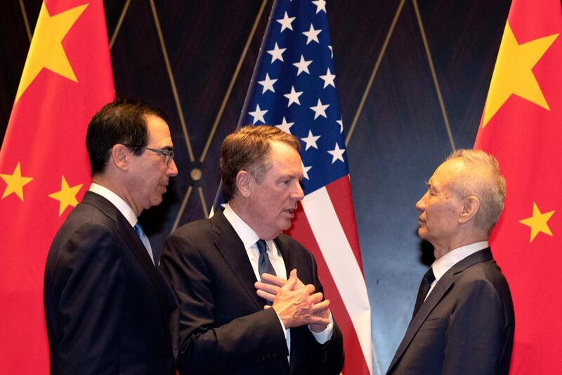 FILE - In this July 31, 2019, file photo U.S. Trade Representative Robert Lighthizer, center, gestures as he chats with Chinese Vice Premier Liu He, at right with Treasury Secretary Steven Mnuchin, left, looking on after posing for a family photo at the Xijiao Conference Center in Shanghai. U.S. and Chinese trade envoys discussed strengthening coordination of their government's economic policies during a phone meeting Tuesday, Aug. 25, 2020, the Ministry of Commerce announced. (AP Photo/Ng Han Guan, Pool, File)