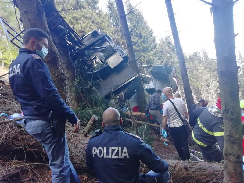 Rescuers survey mangled wreckage at the scene. EPA