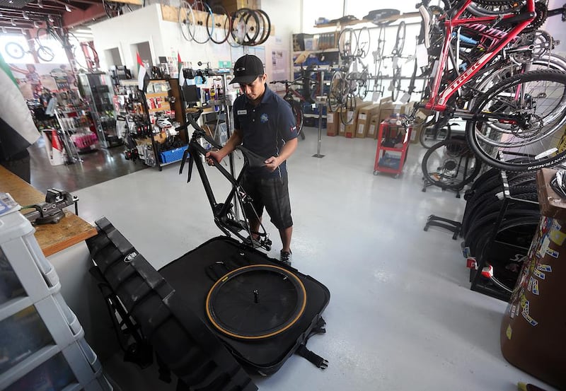 Sherman Jansen De Leon, bike technician at The Cycle Hub in Dubai, demonstrates how to pack a bike for transport using a specialised box. Satish Kumar / The National