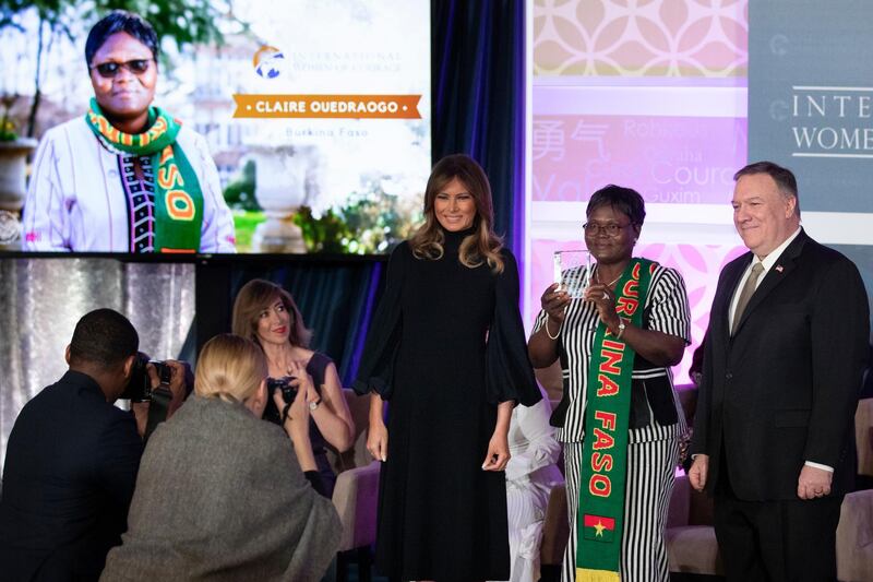 Claire Ouedraogo of Burkina Faso, president of the Songmanegre Association for Women's Development, holds up her award beside US First Lady Melania Trump, left, and Secretary of State Mike Pompeo.  AP