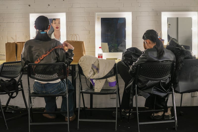 Models sit backstage after showing creations from Beautyberry by Wang Yutao at China Fashion Week in Beijing. AP