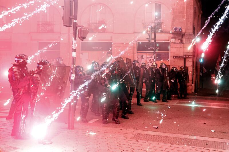 French police shield themselves missiles and fireworks in Nantes. AP