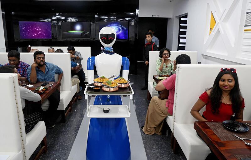 Robots serve trays with food to customers. EPA