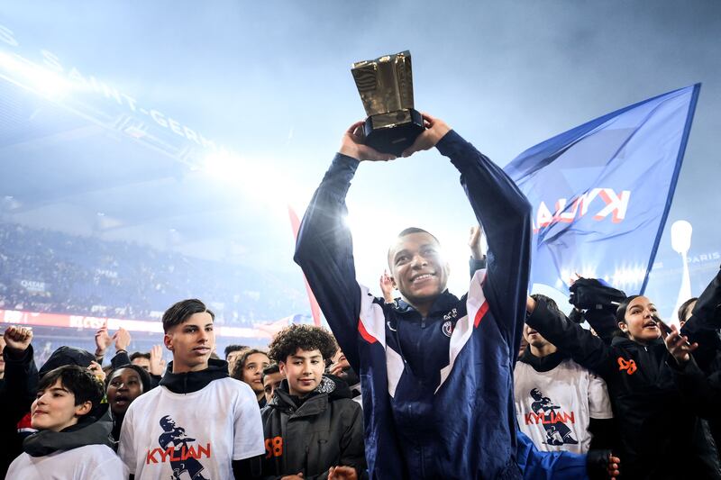Kylian Mbappe lifts the trophy to mark his achievement in becoming PSG's all-time top scorer. AFP