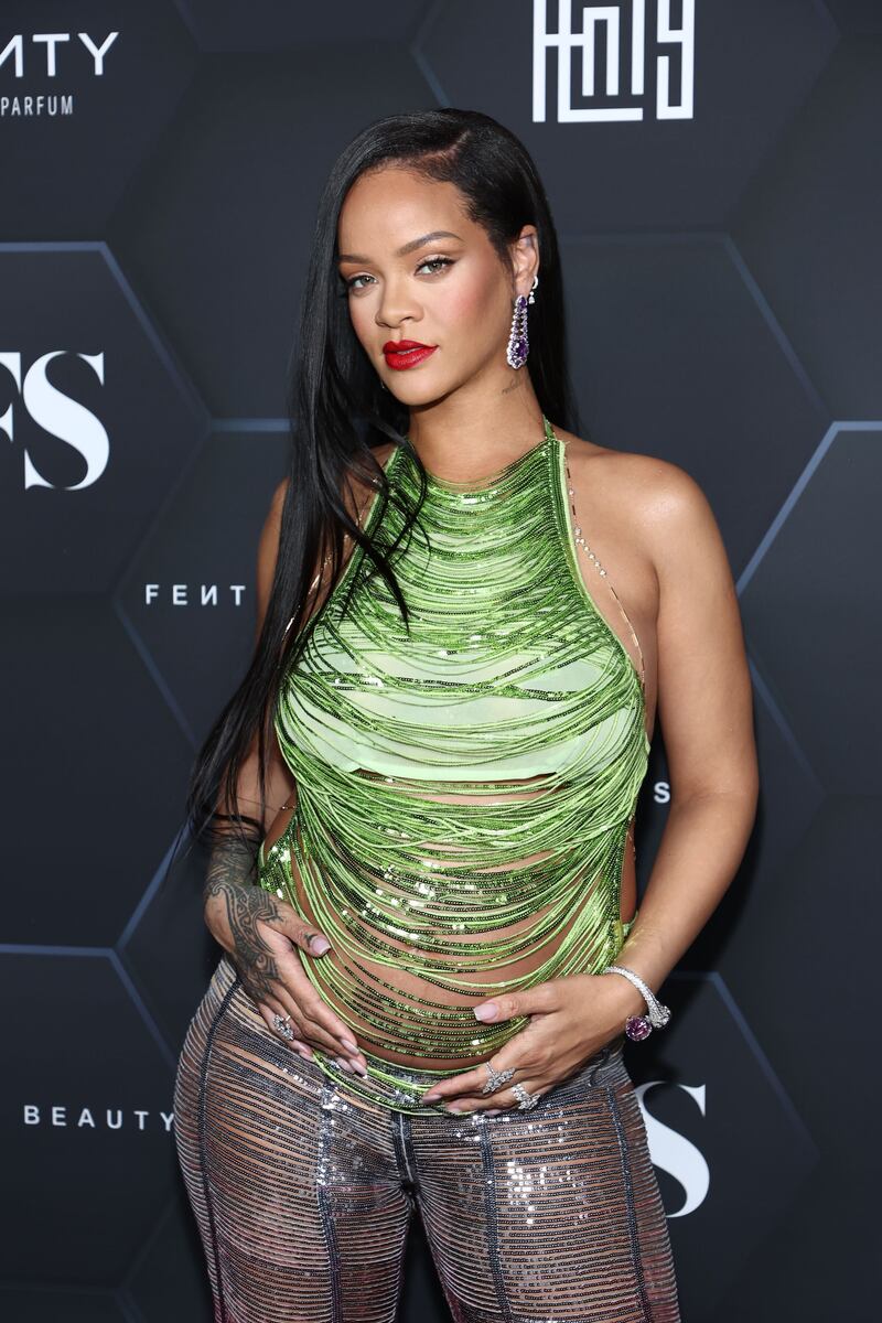 Rihanna's maternity fashion look featured a backless green top and ombre pink trousers. AFP
