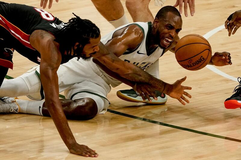 Miami Heat's Trevor Ariza and Milwaukee Bucks' Khris Middleton go after a loose ball during the first half of an NBA basketball game Saturday, May 15, 2021, in Milwaukee. (AP Photo/Morry Gash)