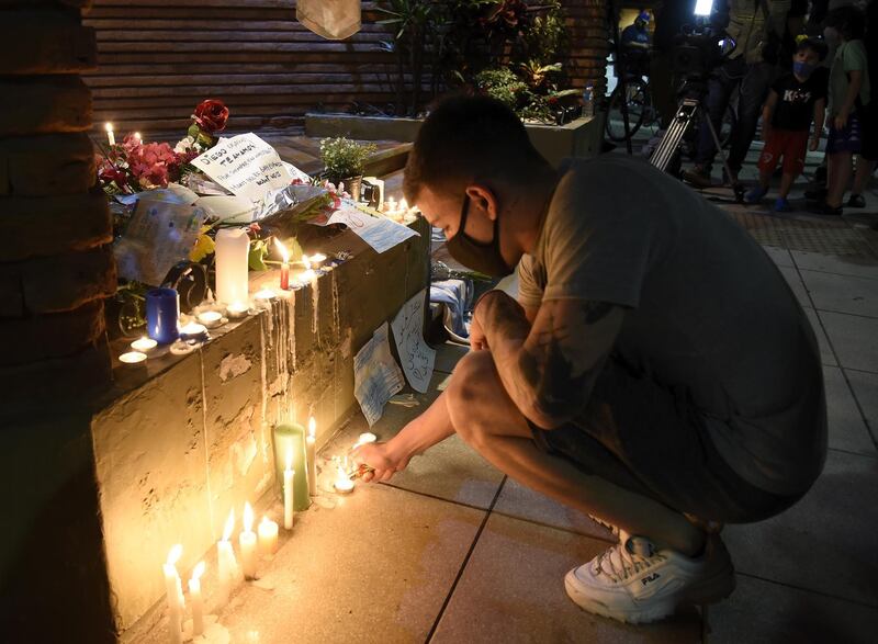 A fan lights a candle to pay tribute to Maradona at the entrance of his former house in Buenos Aires. Getty
