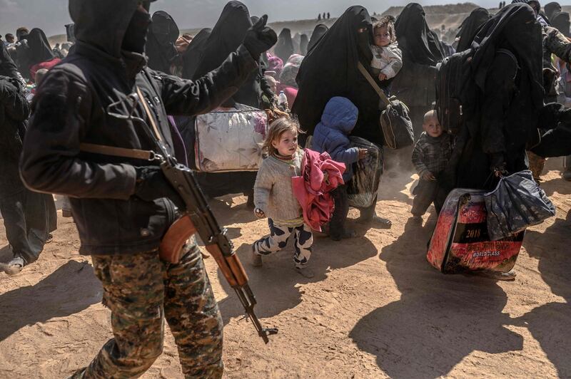 Women and children evacuated from the Islamic State (IS) group's embattled holdout of Baghouz arrive at a screening area held by the US-backed Kurdish-led Syrian Democratic Forces (SDF), in the eastern Syrian province of Deir Ezzor, on March 6, 2019. Veiled women carrying babies and wounded men on crutches hobbled out of the last jihadist village in eastern Syria on March 6 after US-backed forces pummelled the besieged enclave. The Syrian Democratic Forces leading the assault expected more fighters to surrender with their families in tow before moving deeper in the Islamic State group's last redoubt. / AFP / Bulent KILIC
