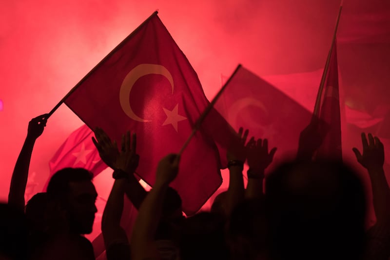 People shout slogans and hold Turkish national flags during a demonstration in Istanbul against the failed army coup attempt in July 2016. EPA / Marius Becker