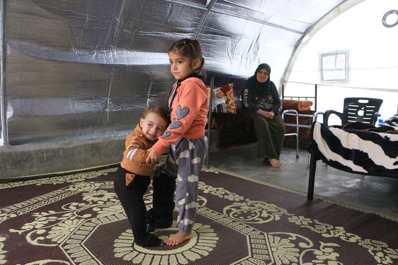 Jinan helps her brother stand as he still has bandages on his feet. Their grandmother is concerned she may not be able to take care of them well enough as she is getting older. Abd Almajed Alkarh / The National