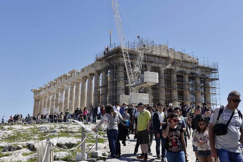 Tourists ring the Acropolis in Athens on Saturday. Like the hugely popular monument, the economy of Greece is in danger of crumbling. Louisa Gouliamaki / AFP