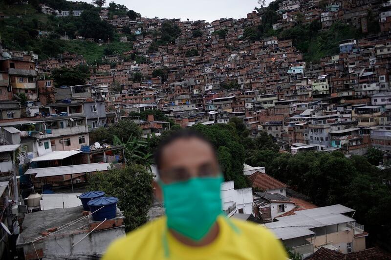 A member of a cultural center wears a mask to protect himself against the spread of the new coronavirus, as he donates food for poor families in Turano favela, Rio de Janeiro, Brazil. AP Photo