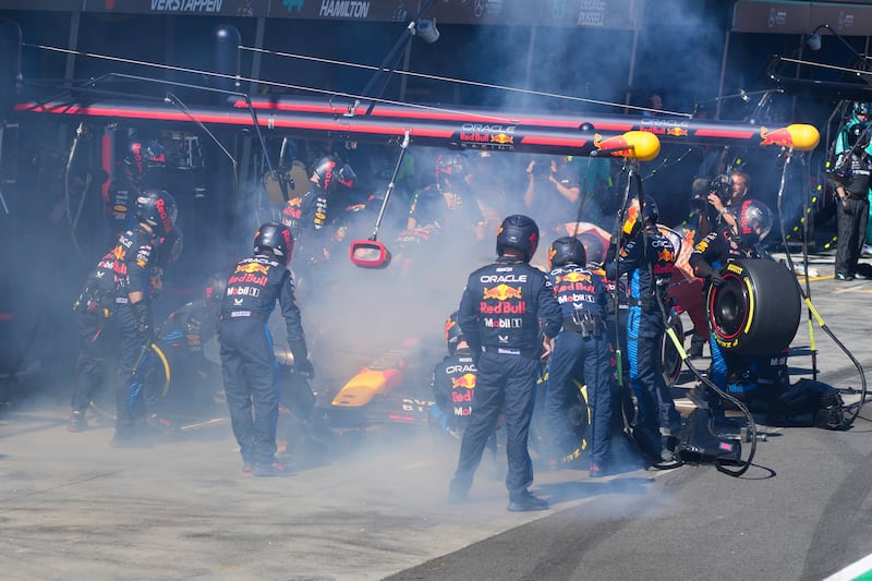Mechanics work to extinguish a fire in Max Verstappen's car. AP