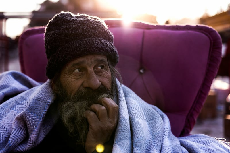 Bedran, a local resident who lost his house in the earthquake, keeps warm in Antakya, Turkey. Reuters