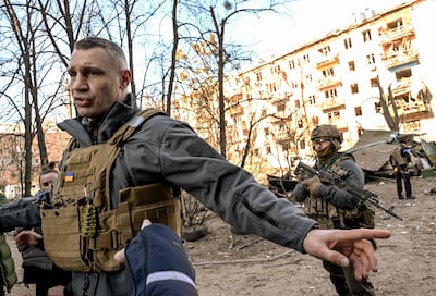 Mayor of Kyiv Vitali Klitschko holds people away from a five-storey residential building that partially collapsed after shelling in the city on Friday. Photo: AFP