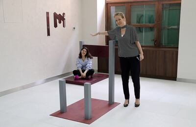 DUBAI, UNITED ARAB EMIRATES, September 4 – 2018 :- Varvara Svishcheva , Museum Manager ( right )  showing the Beuchet Chair illusion at the Museum of Illusions in Al Seef area near the creek in Dubai. ( Pawan Singh / The National )  For Arts & Life/ Big Picture. Story by Felicity Campbell