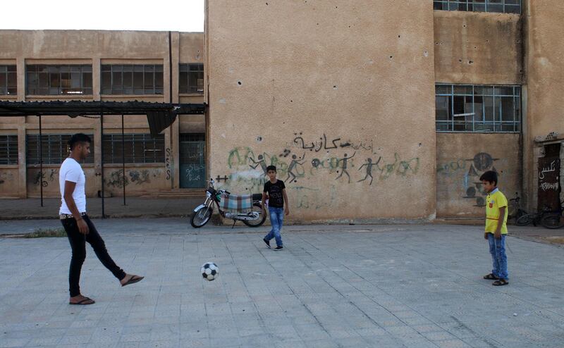 Moawiya Sayasina plays football with other children in a rebel-held neighbourhood in the southern Syrian city of Daraa. Mohamad Abazeed / AFP
