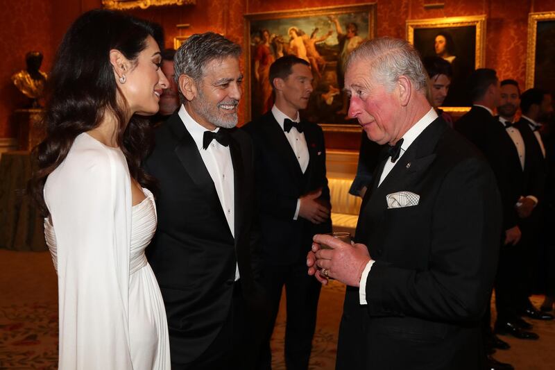 Amal Clooney and George Clooney speak to Prince Charles as attend a dinner to celebrate The Prince's Trust at Buckingham Palace on March 12, 2019 in London, England. Getty Images