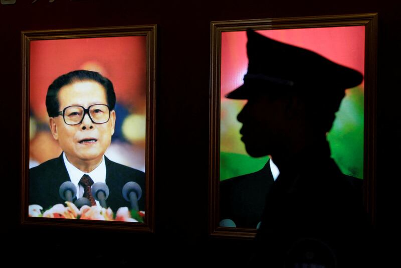 A security guard next to a portrait of China's former president Jiang Zemin at an exhibition to celebrate the 90th anniversary of the founding of the Communist Party of China in Beijing, China, July 7, 2011. Reuters